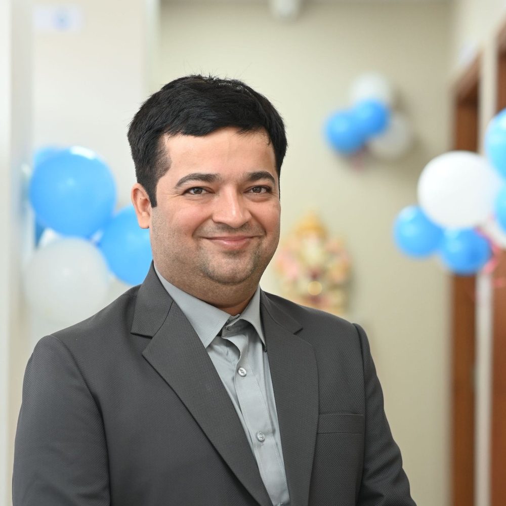 Dr Prashant J. Thakkar, Consultant Physician at Sajivan Hospital, smiling, in a dark suit