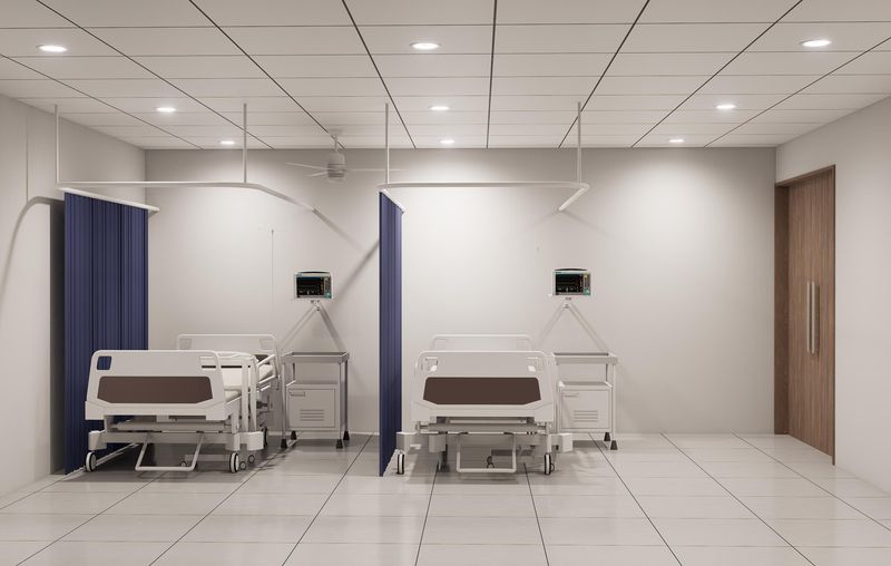 Patient care area with hospital beds, monitors and privacy curtains
